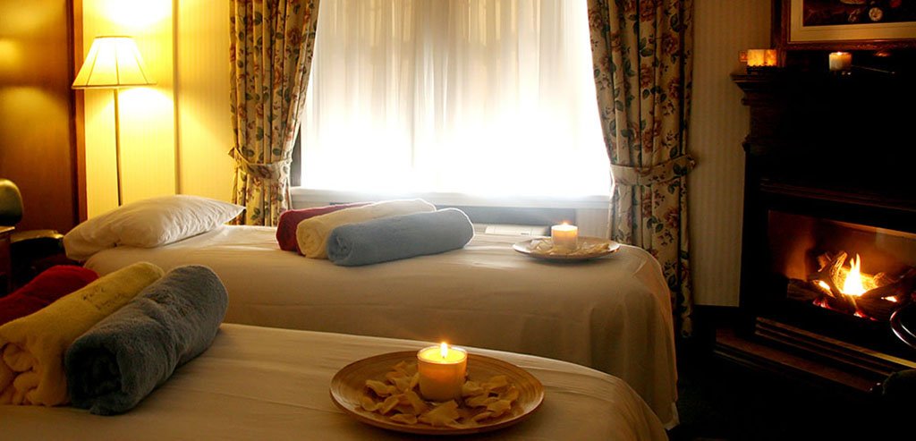 Two massage beds, each with towels and candles.