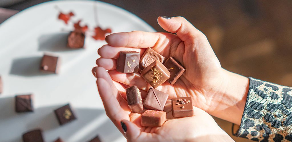 A hand filled with chocolate squares.