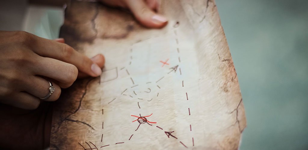 A person holds an old map in their hands.