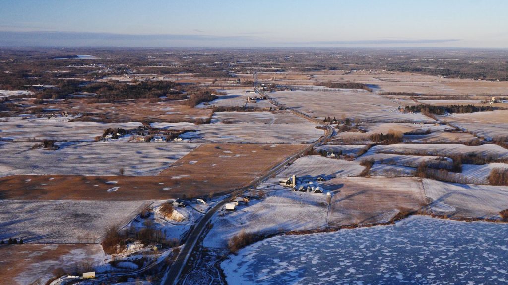 Snow-covered farm fields from a helicopter.