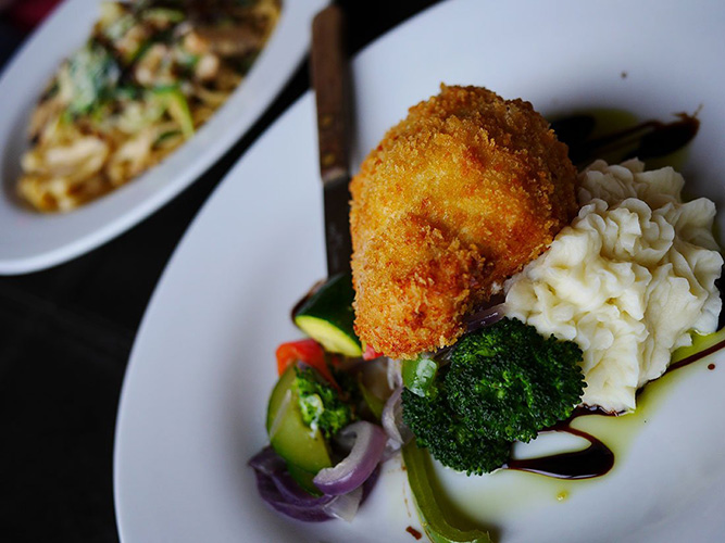 Chicken breast on a plate with vegetables.