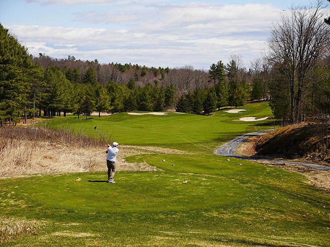 A golfer taking a swing on a course.