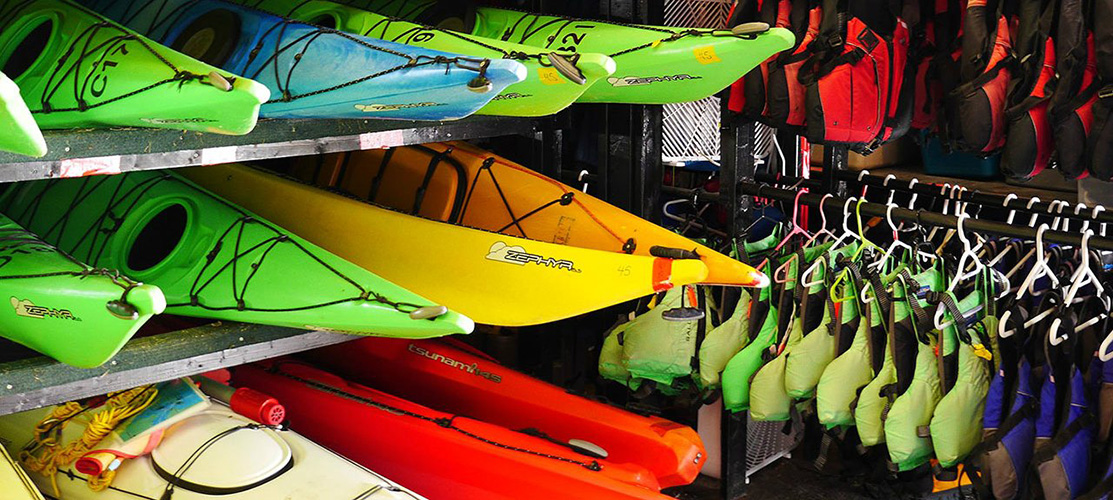 A stand filled with colouful kayaks.