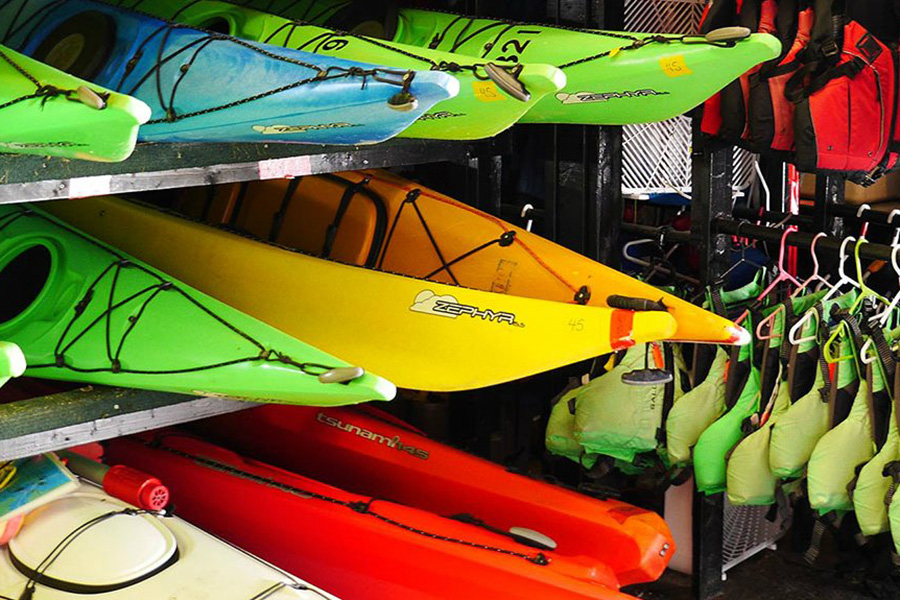 A rack filled with colourful kayaks