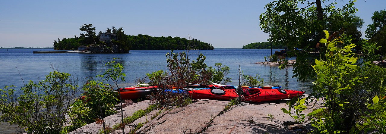 Three kayaks along the banks of the St. Lawrence River. 