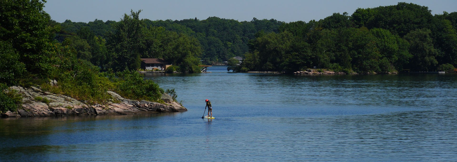 A person paddleboarding on the St. Lawrence River