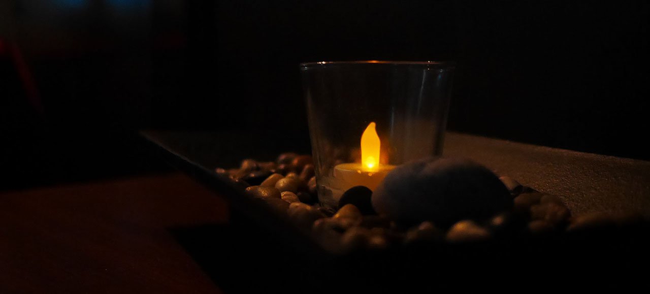 A candle set in the middle of rocks.