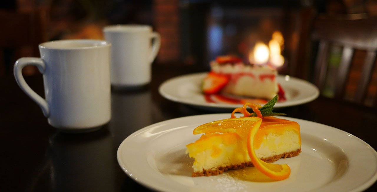 A cheesecake with a cup of coffee beside it.