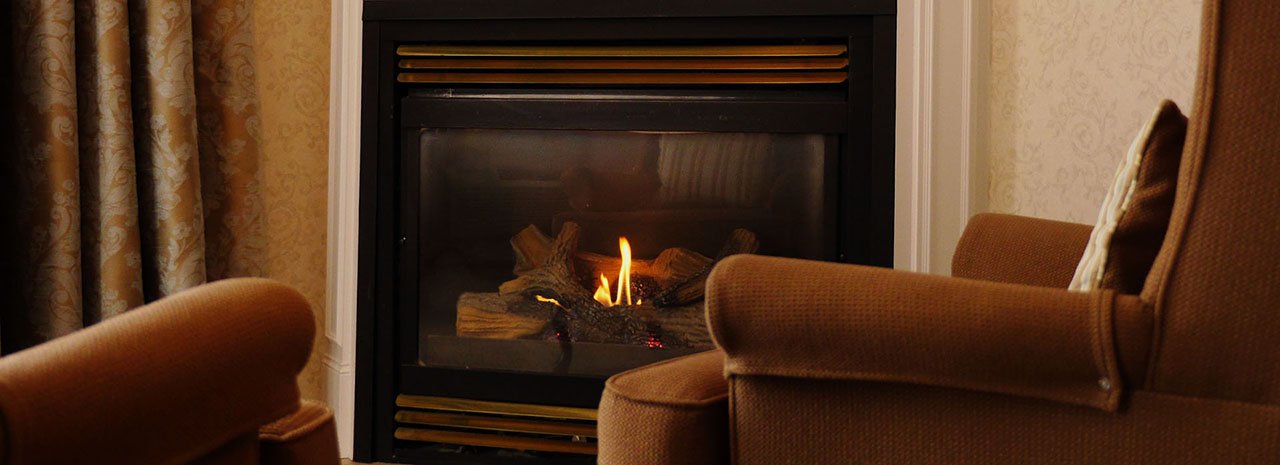 Two chairs in front of a fireplace.