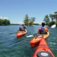 Three kayaks padding the St. Lawrence River.