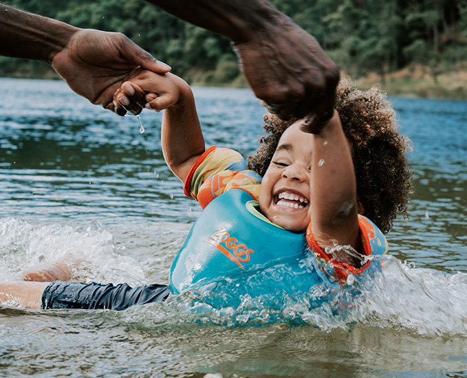 A child swimming with a blue lifejacket