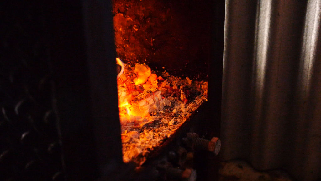 The coals of a fire as maple syrup is boiled.